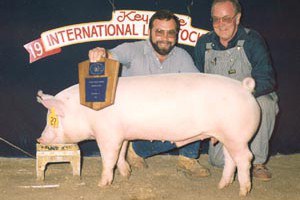 Dave Hosterman (left) and Vernon Hazlett (right), long time swine herdsmen at Penn State, with a show winner.