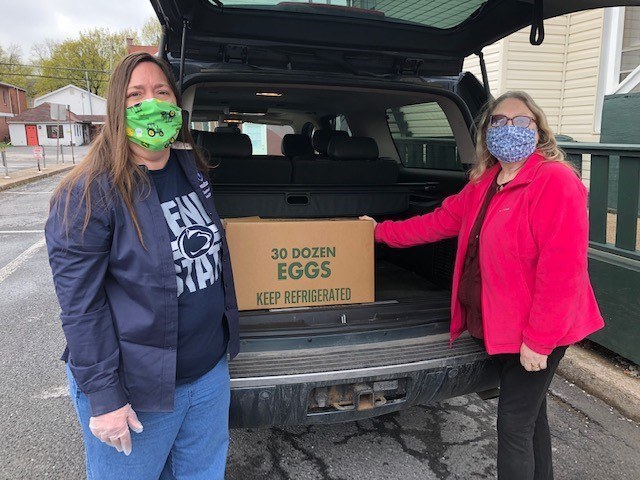 Paula Morgan, administrative support coordinator for the Department of Animal Science, left, recently delivered a case of eggs to Robin Knepp of the Central Pennsylvania Community Action Food Bank in Philipsburg. Image: Amy Duke
