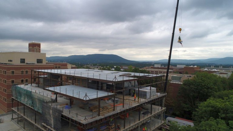The final beam, with a small tree attached, is hoisted to the top of the half-completed Animal, Veterinary and Biomedical Sciences Building on the University Park campus. The facility is expected to be completed in late 2021. IMAGE: Michael Houtz