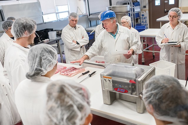 Ed Mills, Associate Professor of Meat Science, works with students in the meats lab.