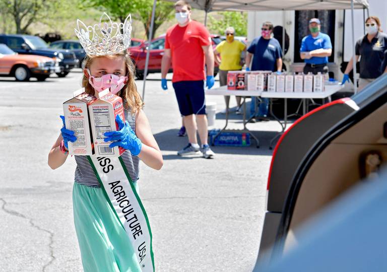 Riley Silvis, 2019 National Petite Miss Agriculture, helps to hand out half gallons of milk Tuesday during a distribution event outside of the Nittany Mall. Photo by Abby Drey